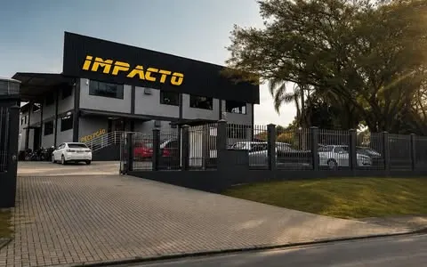Fachada da Impacto Studio Automotivo, prédio preto com o letreiro amarelo
